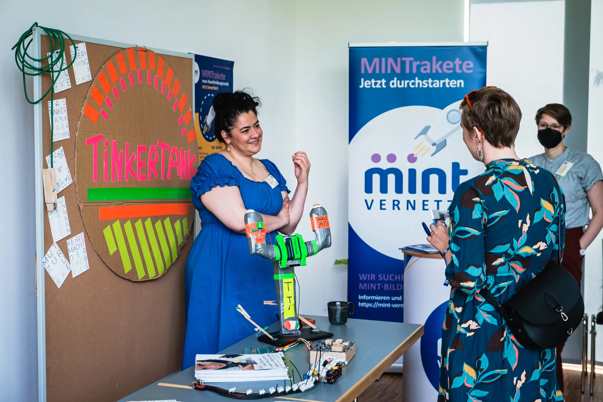 Personen an einem Messestand des Projekts Tinkertank